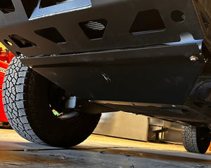 Close-up of a vehicle's undercarriage with a tire and suspension components.
